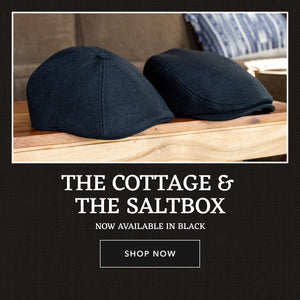 The Cottage and The Saltbox Caps in Black on a wooden surface. Shop Now.