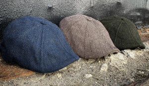 Three Peaky Boston Scally Caps sitting on a concrete background