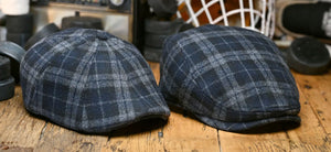 Two Penalty Box Scally Caps on a wooden background