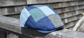 The Saltbox - Blue Patchwork Cap on Wooden Railing